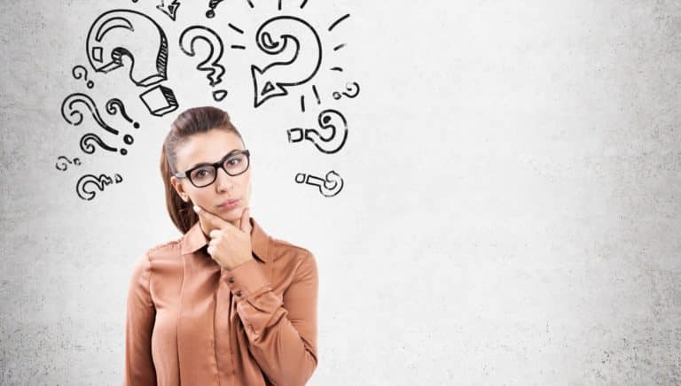 Woman standing with think cloud of question marks.