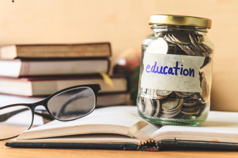 Jar full of coins on a desk that says education on it