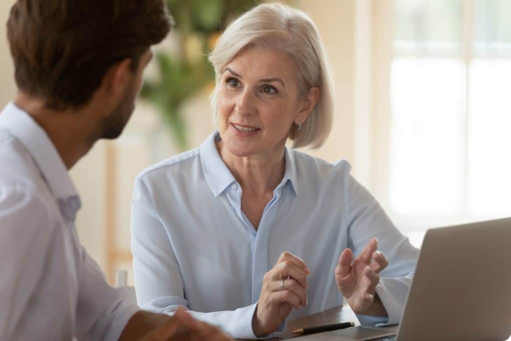 An older advisor has a conversation, mentoring a younger individual.