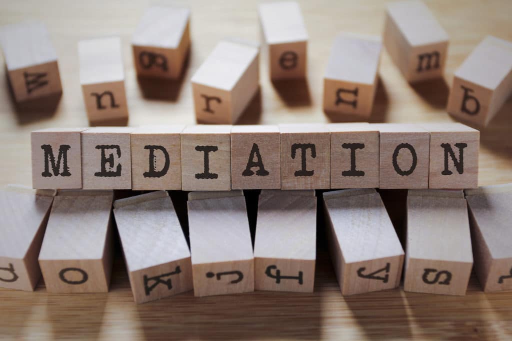 ‘Mediation’ spelled out in wooden blocks surrounded by more wooden blocks.