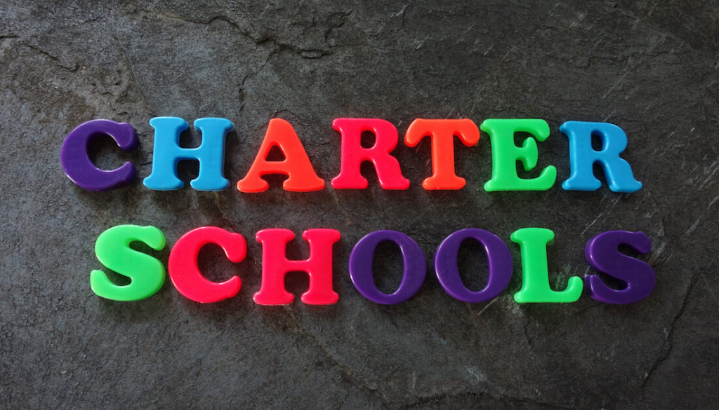 ‘Charter Schools’ spelled out in colorful letters on a black background.