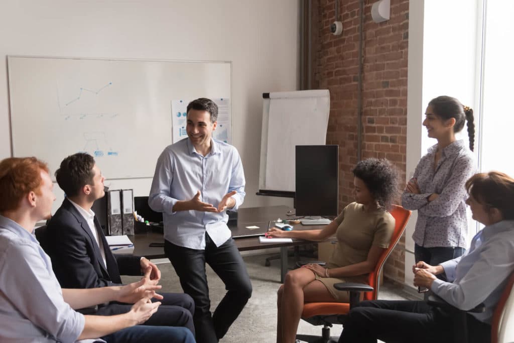 Man talking to a groups of adults sitting in office chairs.