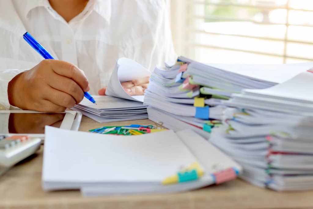 Teacher sitting at their desk grading papers.