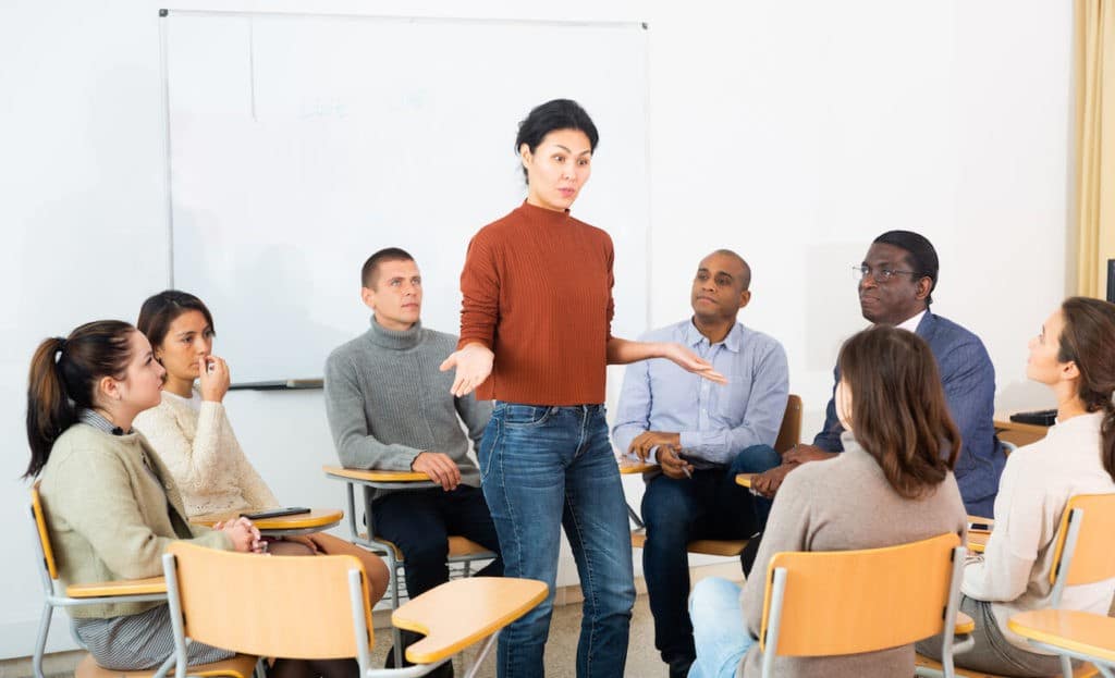 Group of teachers sitting in a circle having a discussion.