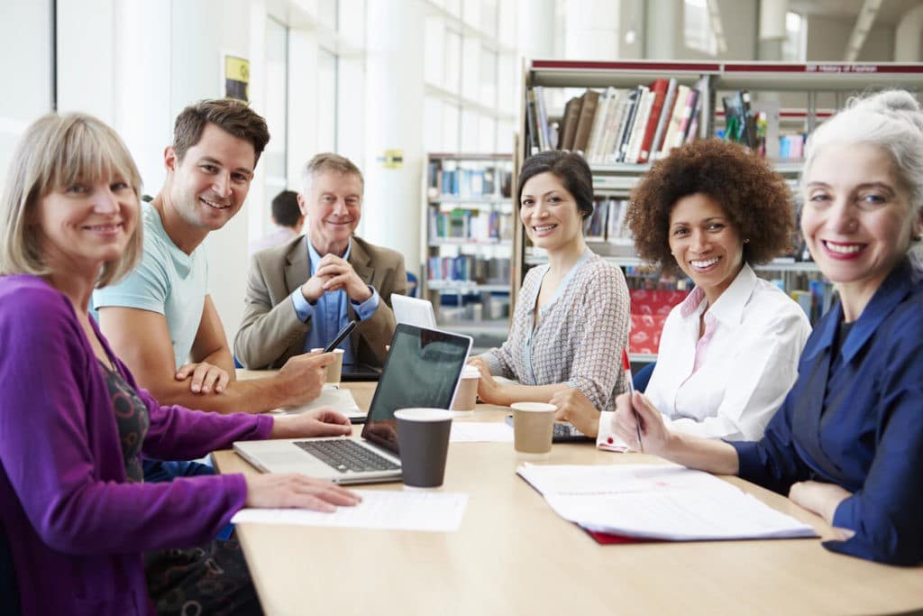 Group of educators working at a table together in the library.