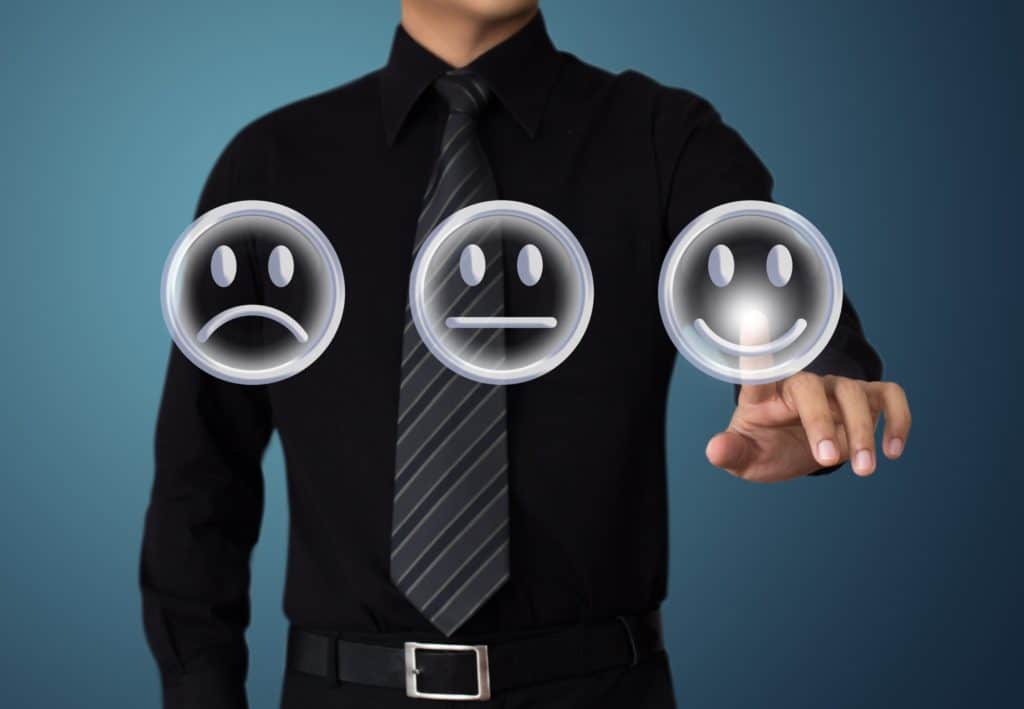 A professional man points to a smiley face indicating his satisfaction.