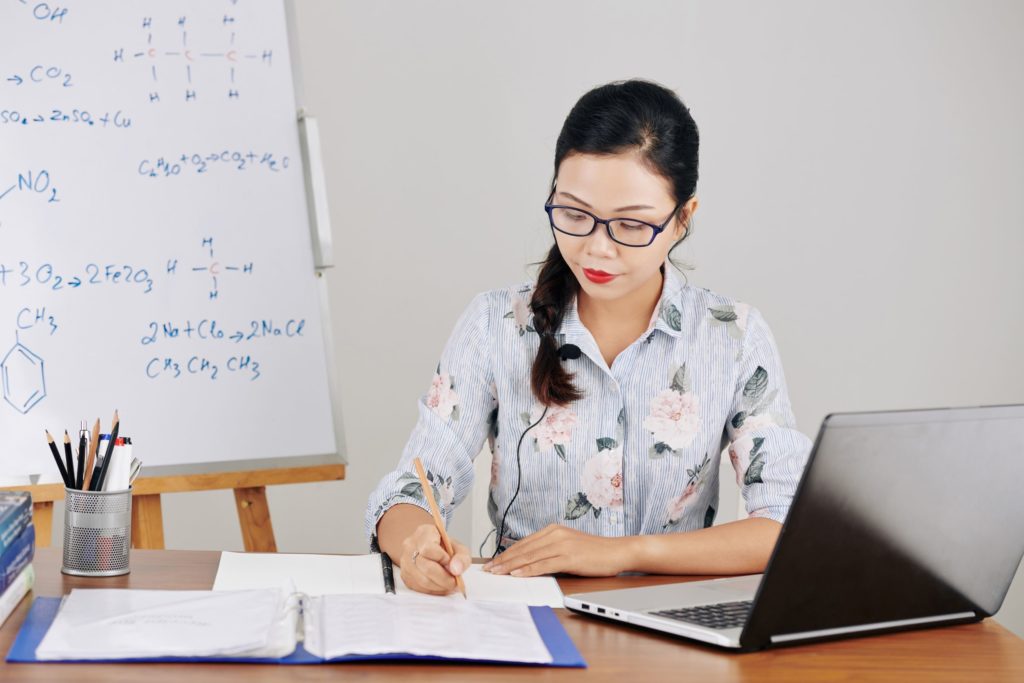 A science teacher sits at her desk, making a lesson plan.