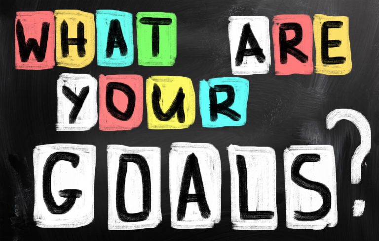 A drawing on a chalkboard reads, “What are your goals?”