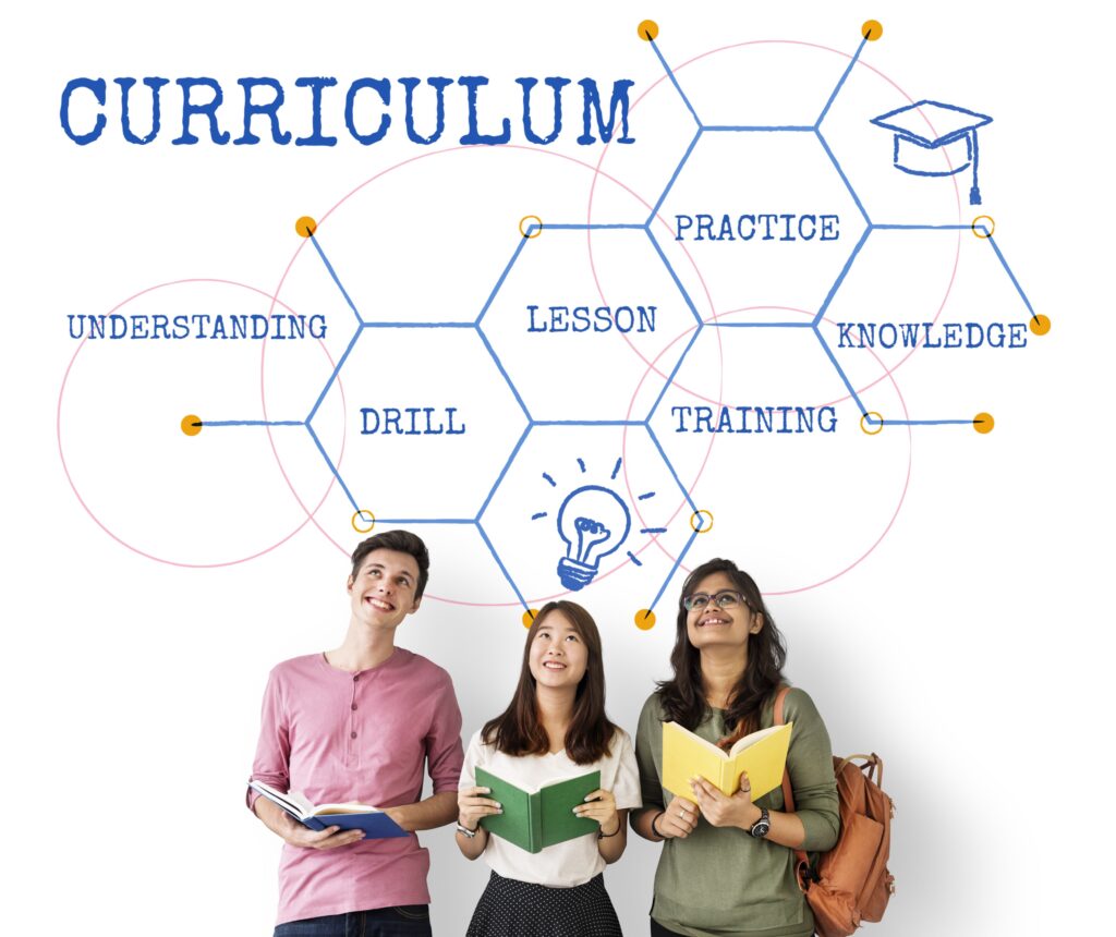 A group of smiling students holding text books stand under the text “curriculum.”