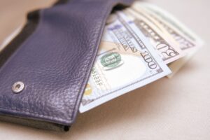 A close-up of a wallet with money sticking out of it.