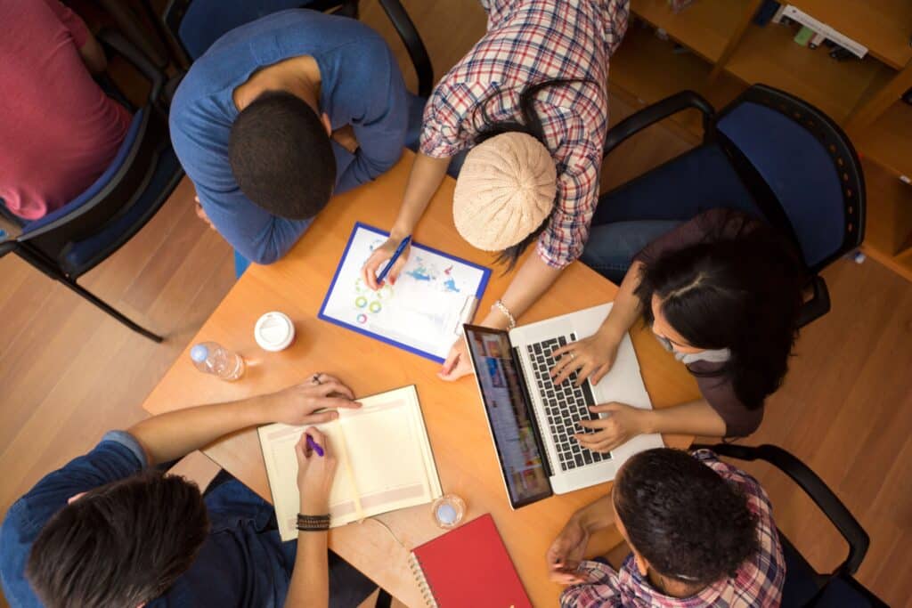 A group of students sit in a circle and participate in classroom review games.