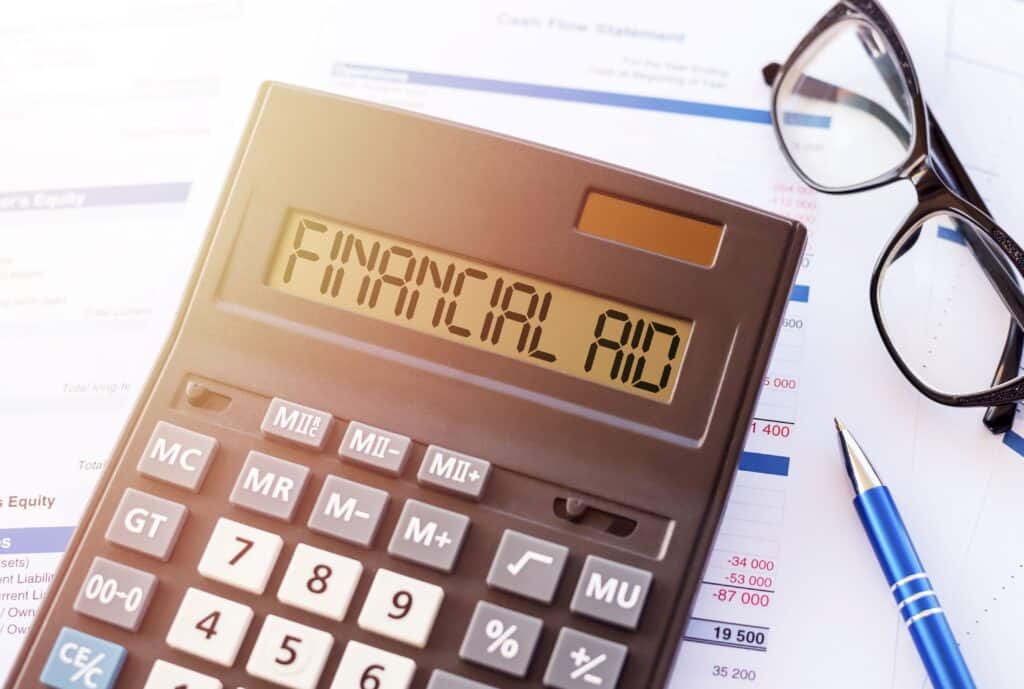 A close-up of a calculator reads, “financial aid.”