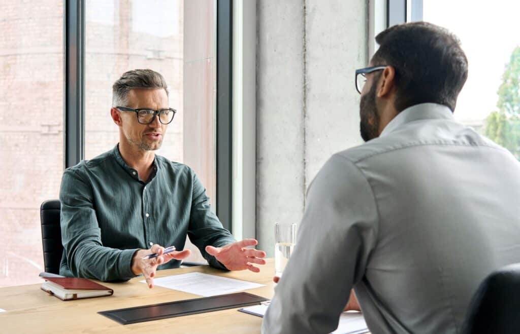 A boss sits with an employee, having a serious conversation.