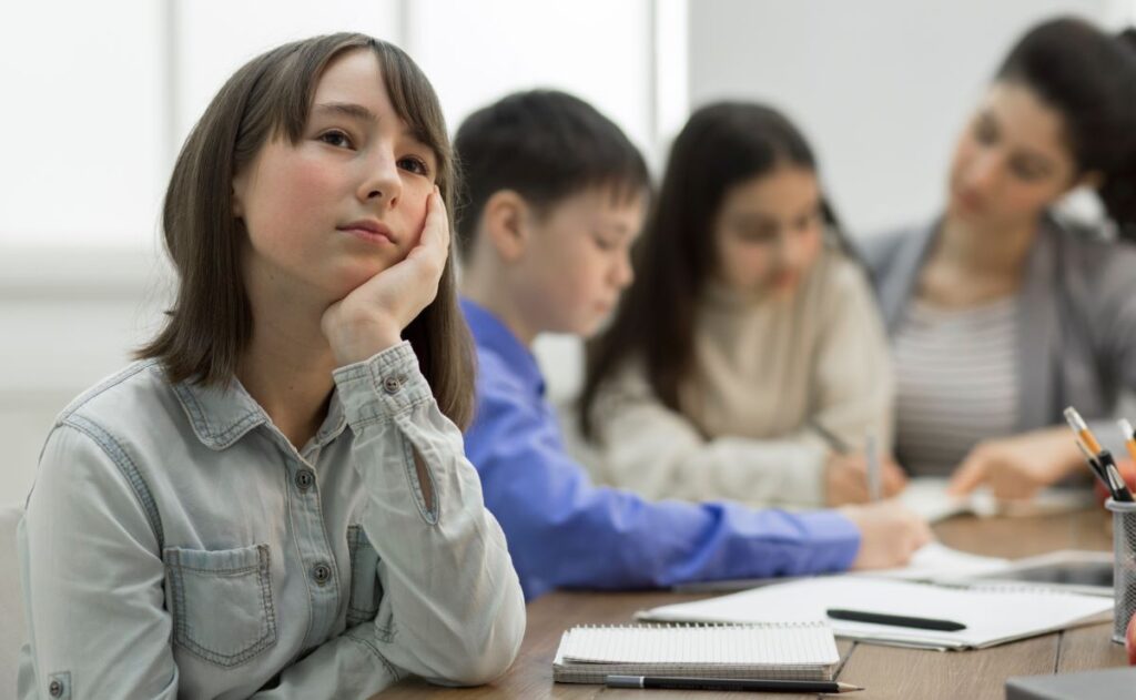 How to improve attention span: a bored student sits in class and daydreams.